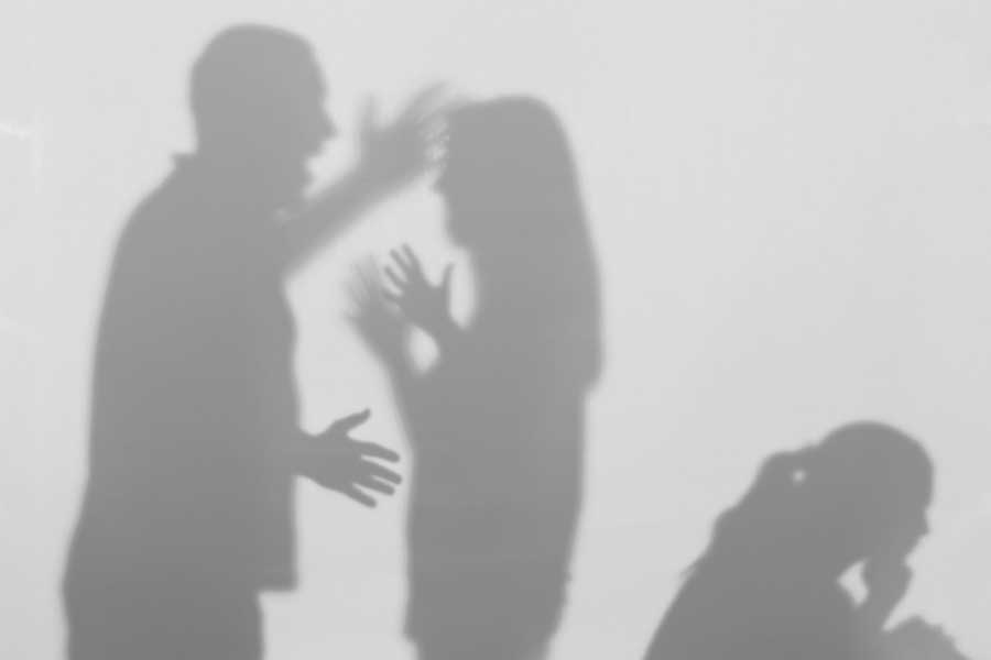 Silhouettes of man and woman arguing and little girl crying