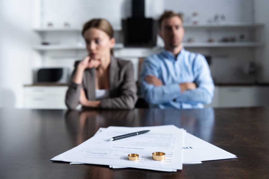 Couple sitting at a kitchen table with divorce documents