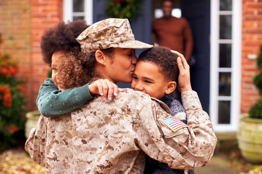 Female US servicemember hugs her children