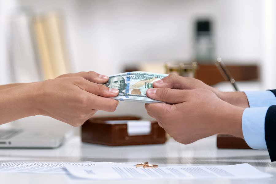 Male and female hands pulling money, illustrating dividing marital assets during divorce