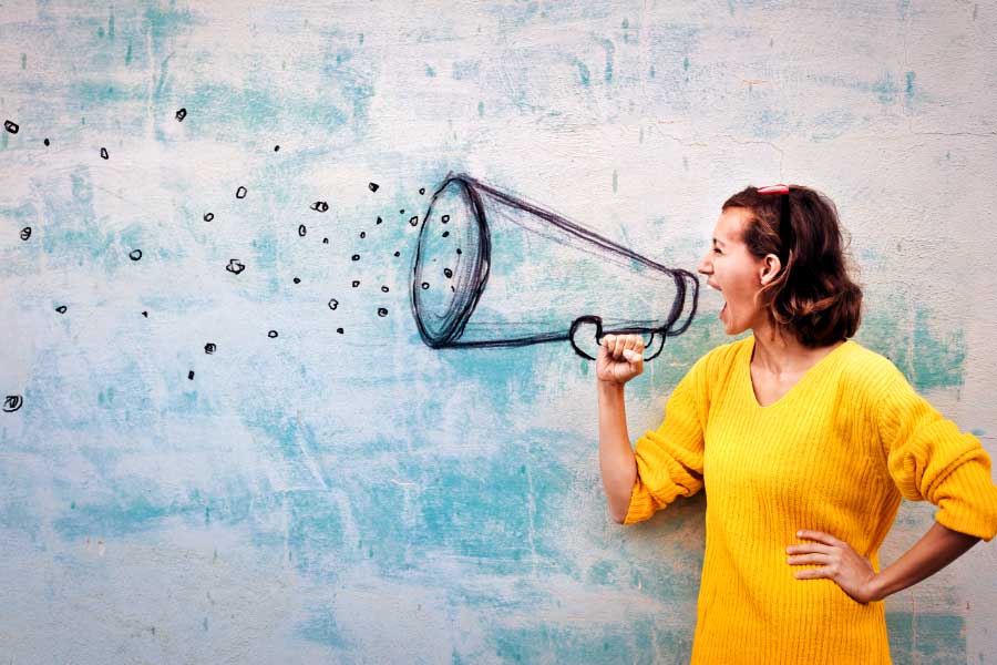 Woman shouting into a megaphone drawn on a wall; communication concept