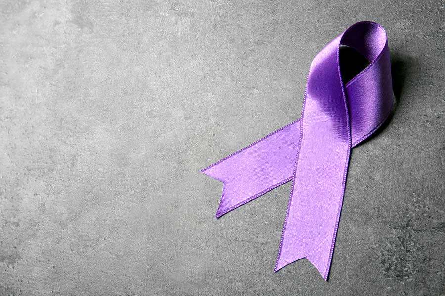 Purple ribbon representing Domestic Violence Awareness Month on a concrete background