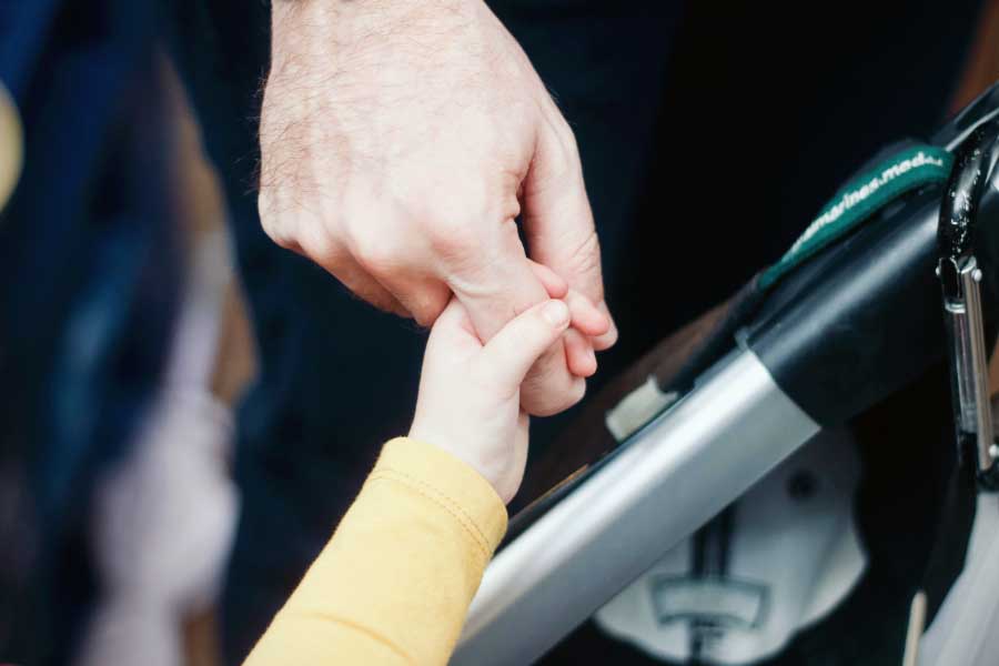 Close up on father's hand holding his child's hand