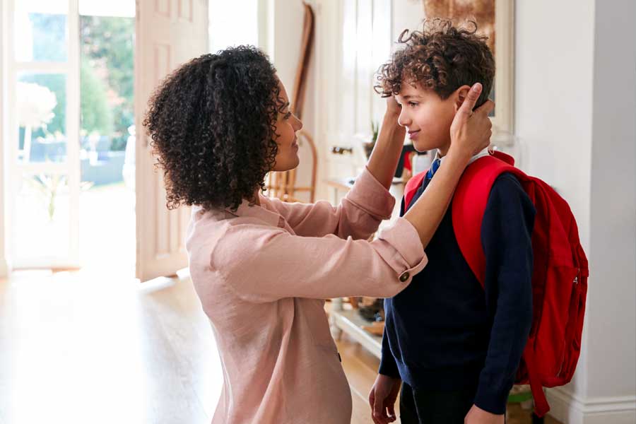 Single mother gets her child ready for first day back to school
