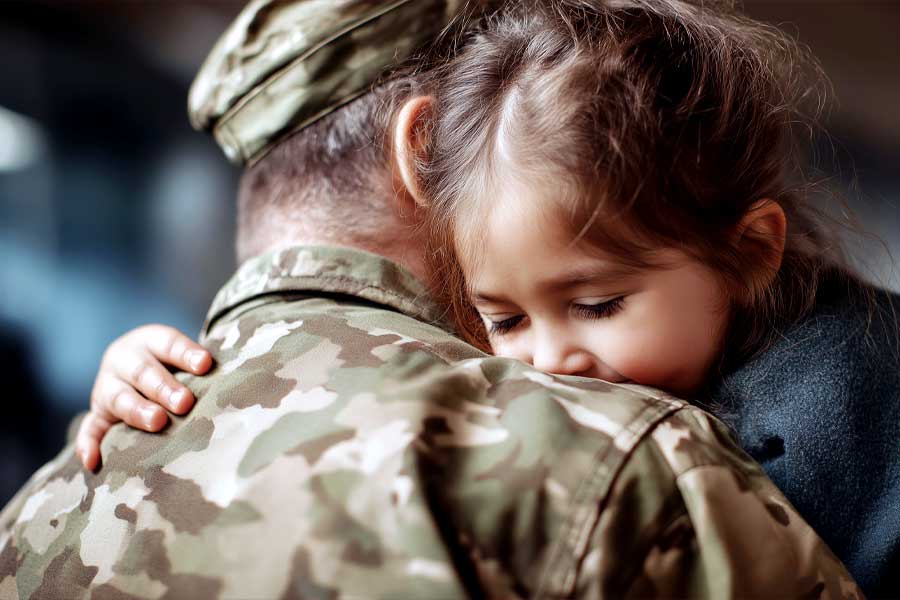 An airmen hugs his young daughter before his deployment