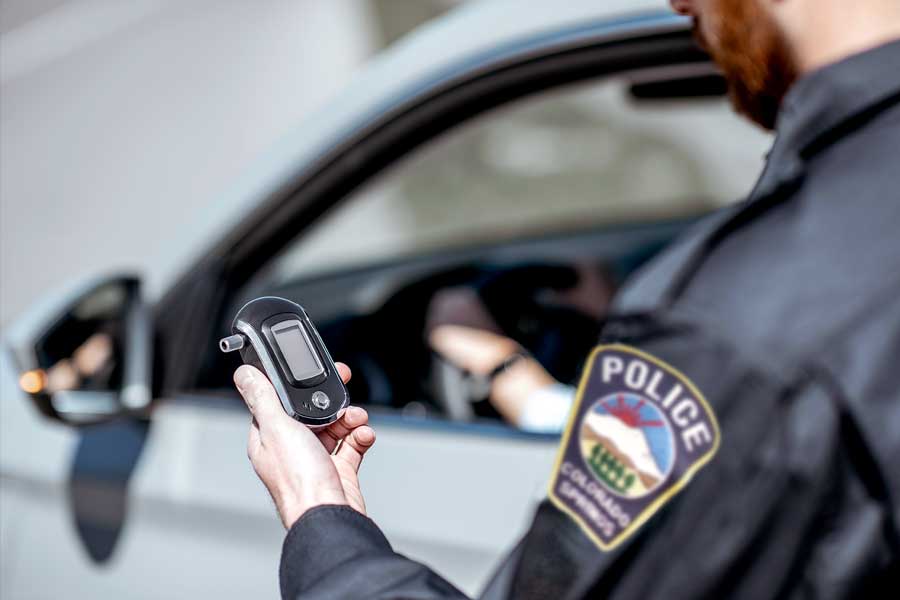 Officer reads the results of a breathalyzer test administered to a driver.