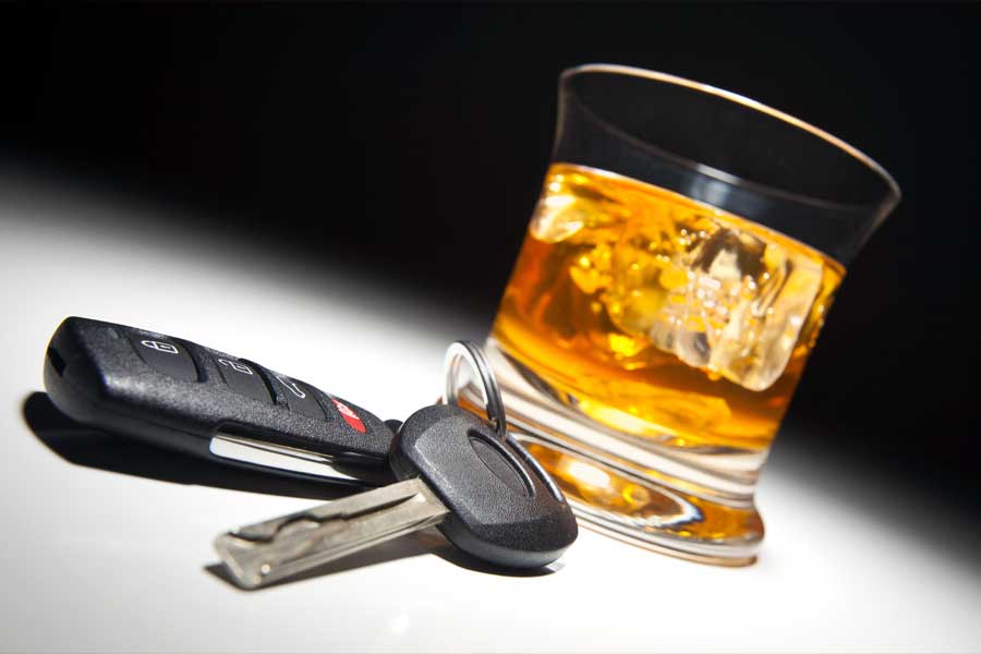A glass of whisky and car keys, illustrating drinking and driving